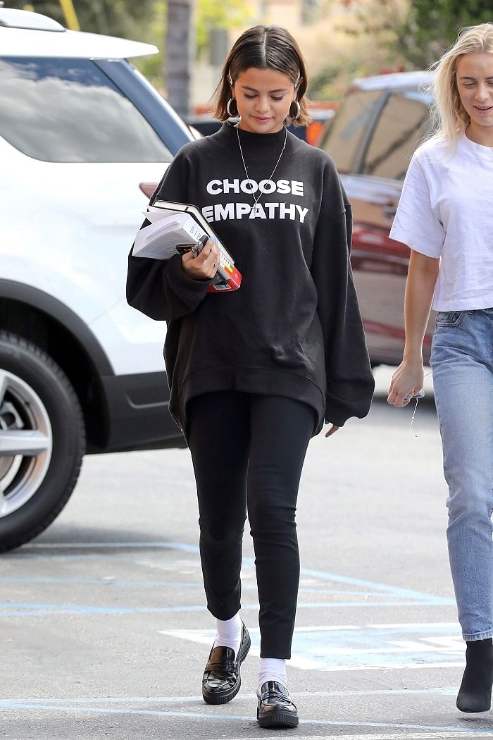 Selena Gomez looks great in a white top and black leggings as she leaves  after a