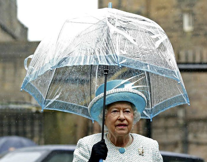 queen-elizabeth-ii-holds-an-umbrella-as-she-visits