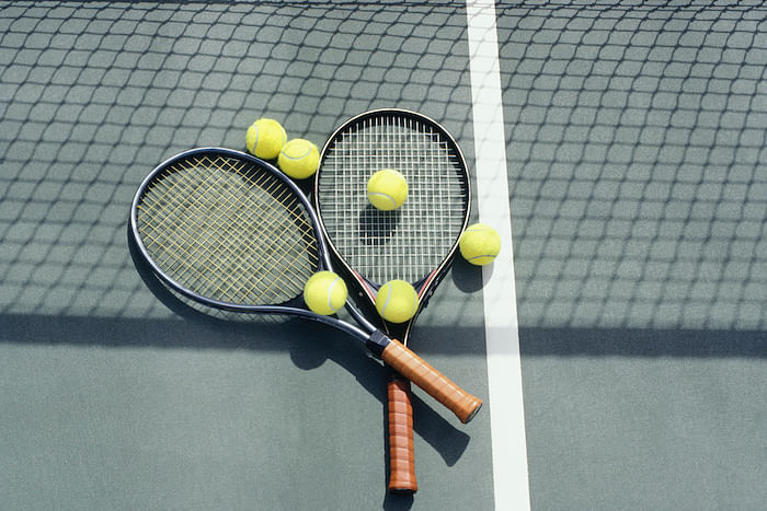 Tennis racquets and balls lying on court